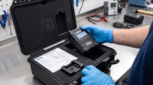 Technician packing a rental air sampling pump kit with calibration certificate