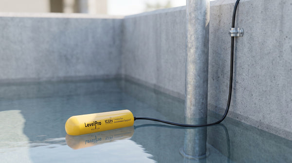 Interrupteur à flotteur LevelPro jaune flottant dans un puisard de béton propre, câble fixé au mur