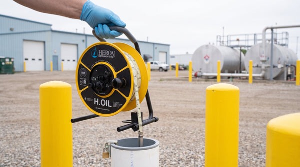 Technician lowering an interface probe reel into a groundwater monitoring well
