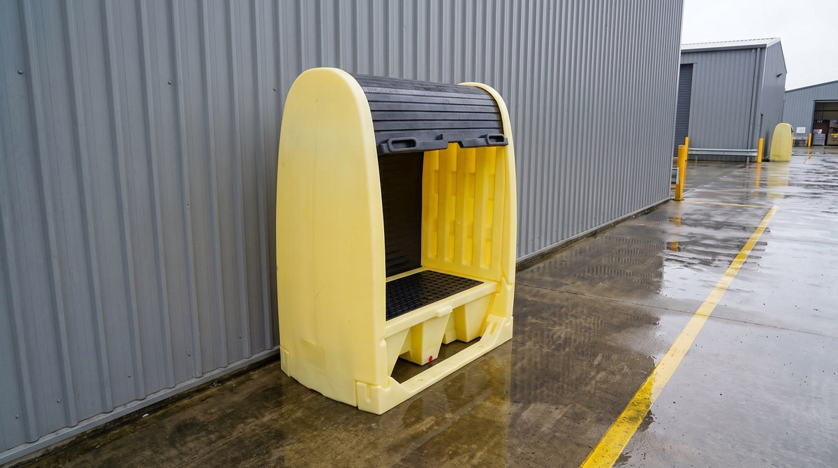 Palette de rétention jaune en polyéthylène avec volet roulant près d'un bâtiment industriel